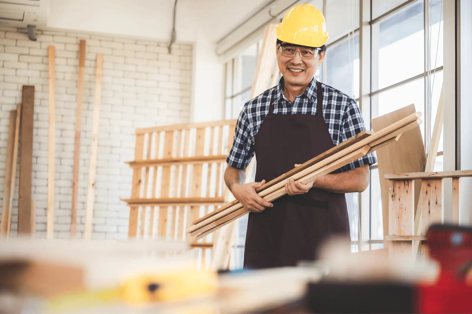 Carpenter holding timber in an unfinished interior workspace