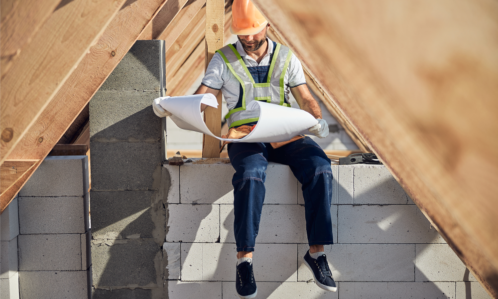 Installing insulation under attic roof beams during a home energy efficiency upgrade in New Jersey